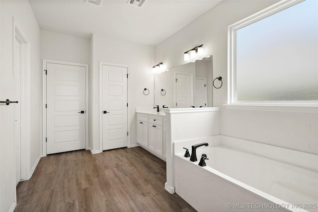 2916 S 8th St, Broken Arrow, OK 74012 - full bathroom featuring vanity, a garden tub, and wood finished floors