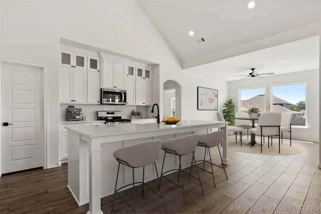 2916 S 8th St, Broken Arrow, OK 74012 - kitchen featuring stainless steel appliances, a kitchen island with sink, a kitchen breakfast bar, light countertops, and decorative backsplash