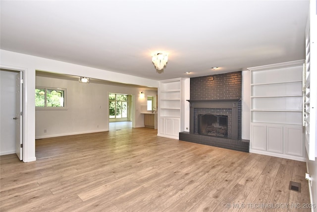 5654 S Marion Ave, Tulsa, OK 74135 - unfurnished living room with a fireplace, light wood-style floors, and built in shelves