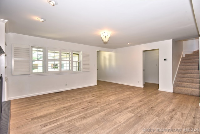 5654 S Marion Ave, Tulsa, OK 74135 - unfurnished living room with stairway and light wood-type flooring