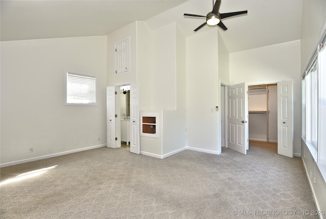 5654 S Marion Ave, Tulsa, OK 74135 - unfurnished bedroom with high vaulted ceiling, carpet, multiple windows, ceiling fan, and a walk in closet