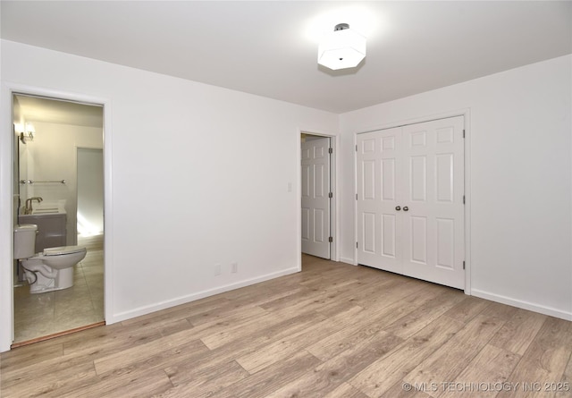 5654 S Marion Ave, Tulsa, OK 74135 - unfurnished bedroom featuring light wood-style floors, a closet, and ensuite bathroom