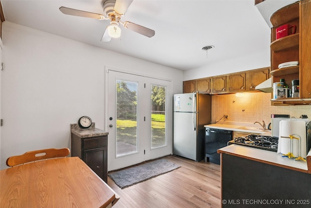 2321 S Main St, Sapulpa, OK 74066 - kitchen with freestanding refrigerator, black dishwasher, open shelves, decorative backsplash, and light wood finished floors