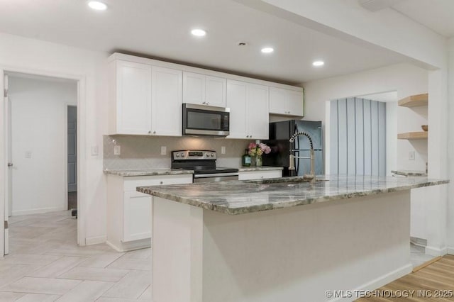 6016 S 76th E Ave, Tulsa, OK 74145 - kitchen with stainless steel appliances, white cabinetry, open shelves, tasteful backsplash, and light stone countertops