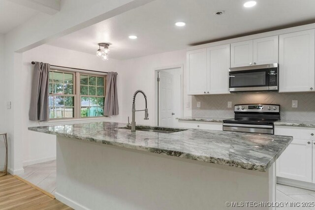 6016 S 76th E Ave, Tulsa, OK 74145 - kitchen with stainless steel appliances, white cabinetry, an island with sink, backsplash, and recessed lighting