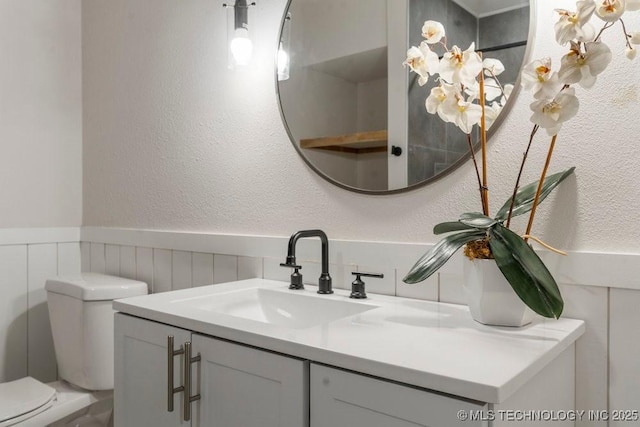 6016 S 76th E Ave, Tulsa, OK 74145 - half bathroom featuring vanity, wainscoting, and a textured wall