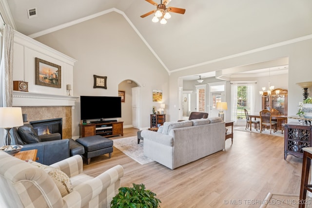 12432 S 101st E Ave, Bixby, OK 74008 - living room with light wood-style floors, a ceiling fan, a tiled fireplace, high vaulted ceiling, and arched walkways