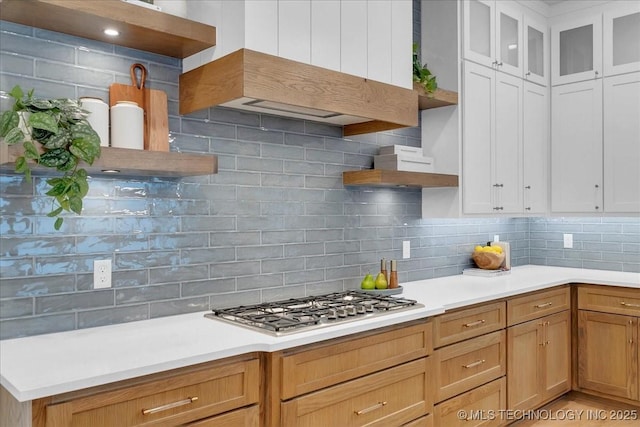 1207 N 71st Pl, Broken Arrow, OK 74014 - kitchen with open shelves, stainless steel gas stovetop, backsplash, light countertops, and glass insert cabinets