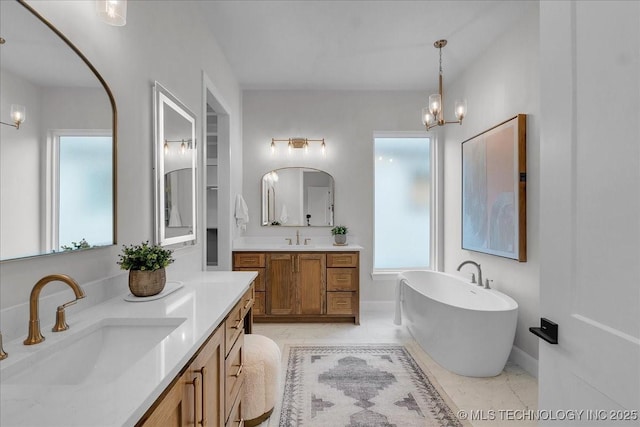 1207 N 71st Pl, Broken Arrow, OK 74014 - bathroom featuring a freestanding tub, two vanities, plenty of natural light, and a chandelier