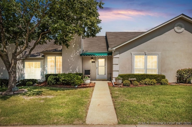 8318 S 84th E Ave, Tulsa, OK 74133 - view of front of house with a yard, stucco siding, and roof with shingles