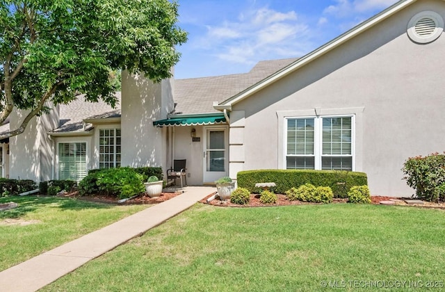 8318 S 84th E Ave, Tulsa, OK 74133 - property entrance featuring a yard and stucco siding