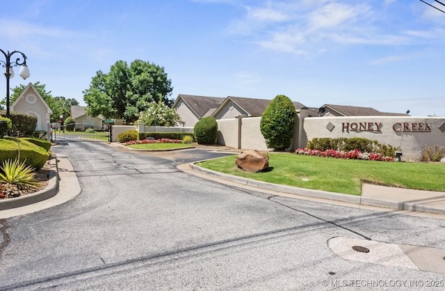 8318 S 84th E Ave, Tulsa, OK 74133 - view of asphalt road featuring curbs, a gate, a gated entry, and street lighting