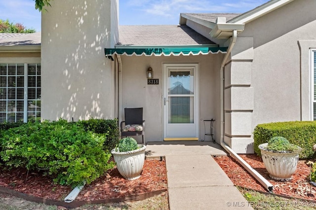 8318 S 84th E Ave, Tulsa, OK 74133 - view of exterior entry featuring a shingled roof and stucco siding