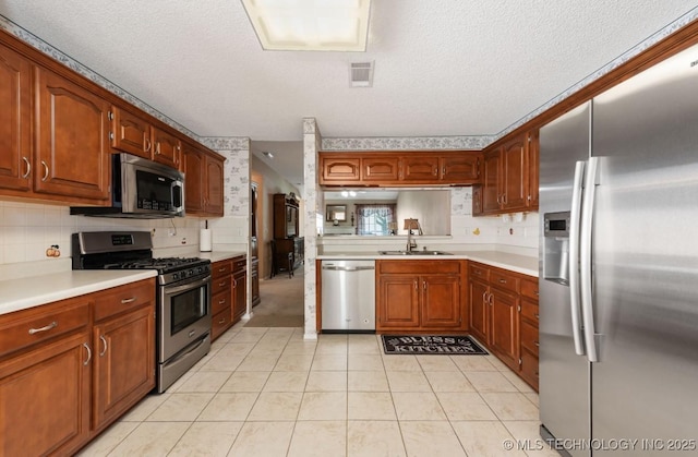 8318 S 84th E Ave, Tulsa, OK 74133 - kitchen with stainless steel appliances, light countertops, decorative backsplash, and a textured ceiling