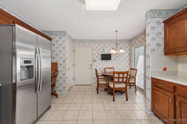8318 S 84th E Ave, Tulsa, OK 74133 - dining room featuring wallpapered walls, a textured ceiling, a chandelier, and light tile patterned flooring