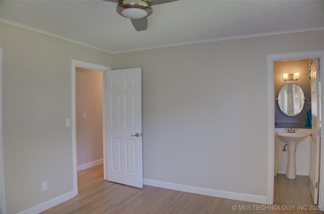 4424 E 59th Pl S, Tulsa, OK 74135 - unfurnished bedroom with a textured ceiling, wood finished floors, ornamental molding, connected bathroom, and ceiling fan