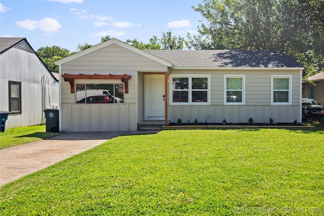 227 S Toledo Ave, Tulsa, OK 74112 - view of front of property featuring board and batten siding, a front lawn, and a shingled roof