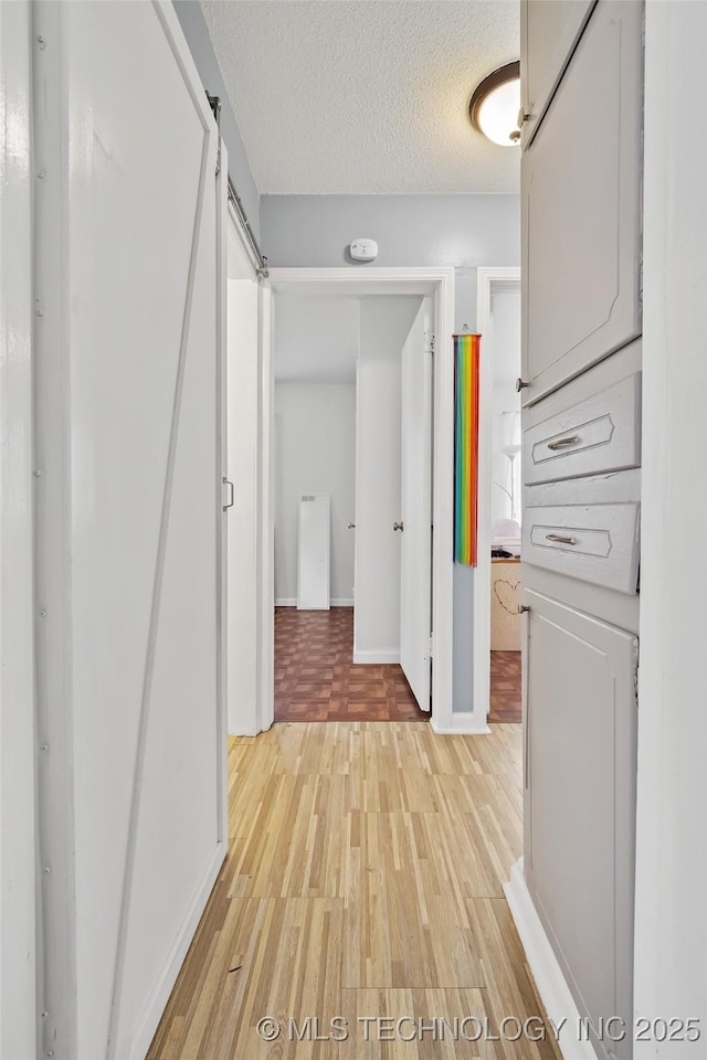 12750 E 23rd St, Tulsa, OK 74129 - corridor with light wood-type flooring and a textured ceiling