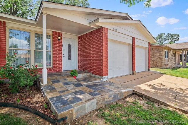 12750 E 23rd St, Tulsa, OK 74129 - view of front of home featuring a garage, brick siding, and driveway