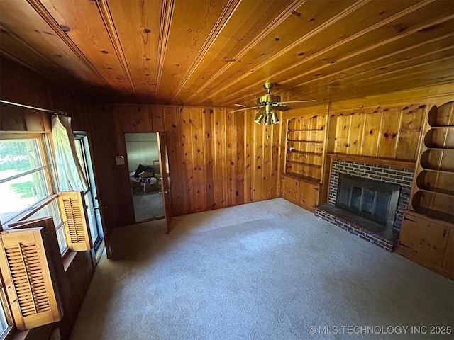 4905 S Columbia Ave, Tulsa, OK 74105 - unfurnished living room with wooden walls, a brick fireplace, carpet, ceiling fan, and wooden ceiling