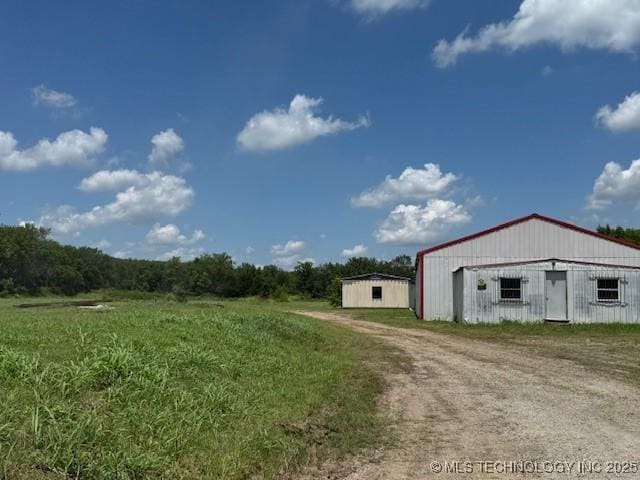 2019 W 53rd St N, Tulsa, OK 74126 - view of yard with driveway, an outbuilding, a detached garage, and a pole building
