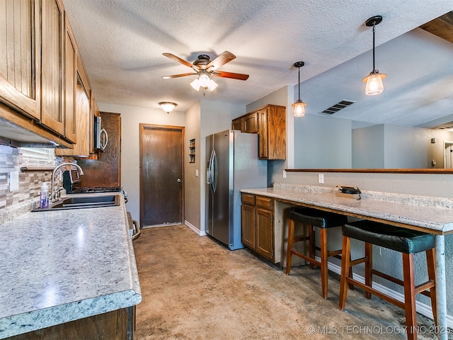 25136 Hickory Ln, Broken Arrow, OK 74014 - kitchen with appliances with stainless steel finishes, brown cabinets, ceiling fan, a textured ceiling, and light countertops