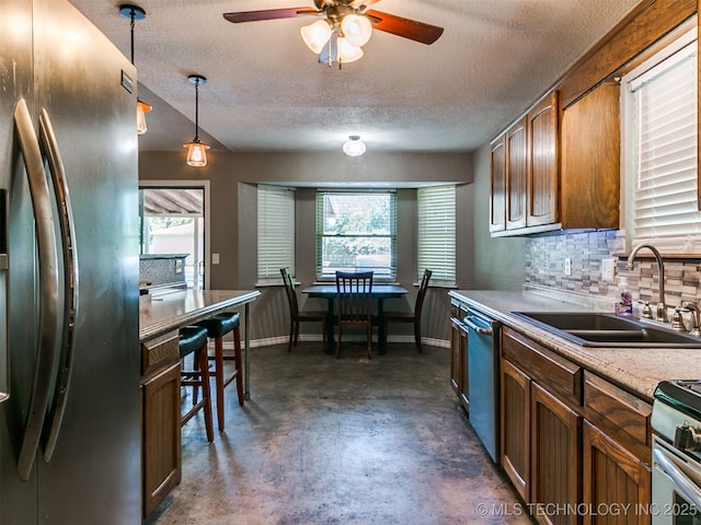 25136 Hickory Ln, Broken Arrow, OK 74014 - kitchen featuring appliances with stainless steel finishes, concrete floors, ceiling fan, a textured ceiling, and decorative light fixtures