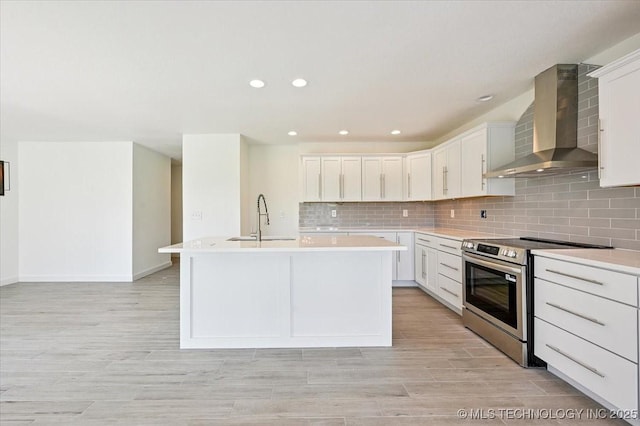 13973 S 237th E Ave, Coweta, OK 74429 - kitchen with stainless steel electric range, wall chimney exhaust hood, light countertops, tasteful backsplash, and a kitchen island with sink