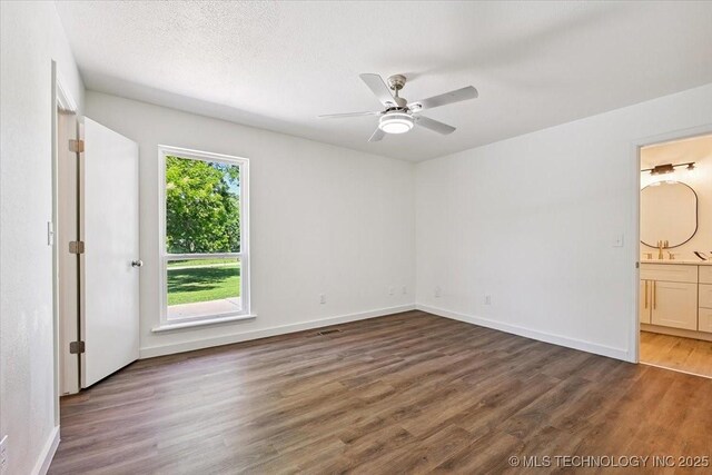 13973 S 237th E Ave, Coweta, OK 74429 - unfurnished bedroom featuring wood finished floors, ensuite bath, and a ceiling fan