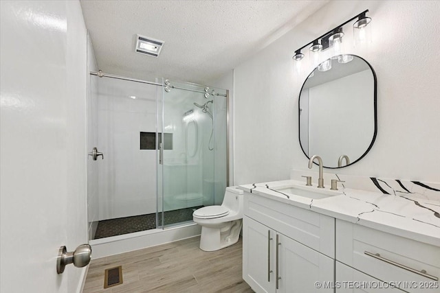 13973 S 237th E Ave, Coweta, OK 74429 - bathroom featuring vanity, a stall shower, wood finished floors, and a textured ceiling