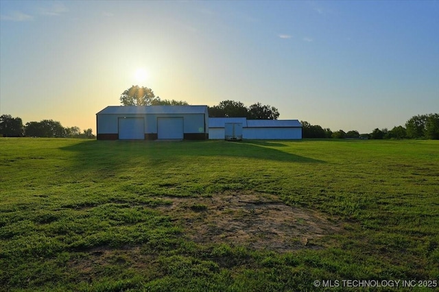 13973 S 237th E Ave, Coweta, OK 74429 - yard at dusk with a lawn, a garage, an outbuilding, and a rural view