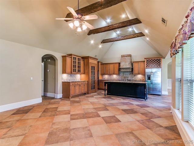 9314 S 76th E Ave, Tulsa, OK 74133 - kitchen featuring stainless steel refrigerator with ice dispenser, premium range hood, arched walkways, brown cabinets, and a ceiling fan