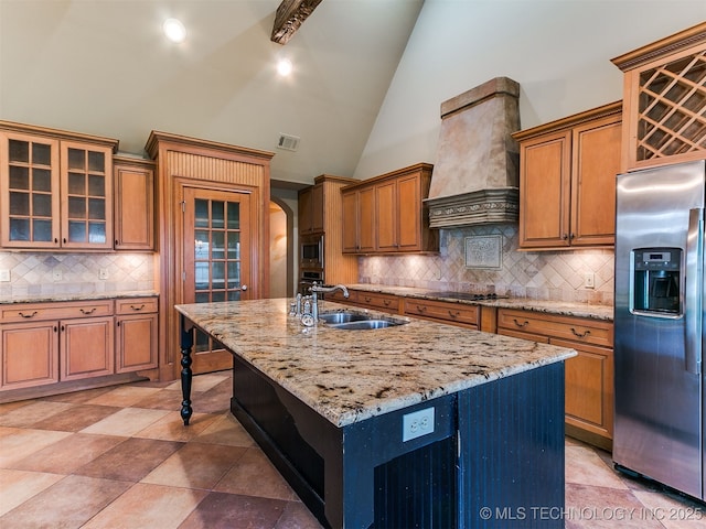 9314 S 76th E Ave, Tulsa, OK 74133 - kitchen featuring appliances with stainless steel finishes, custom exhaust hood, backsplash, brown cabinets, and arched walkways