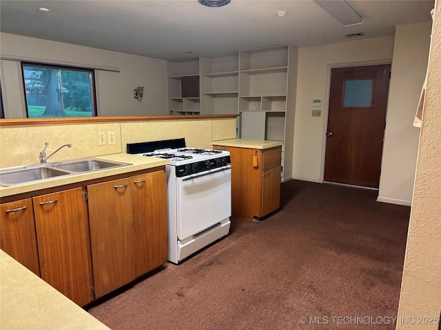 2306 Hill Dr, Bartlesville, OK 74006 - kitchen with white gas stove, brown cabinets, dark carpet, and light countertops