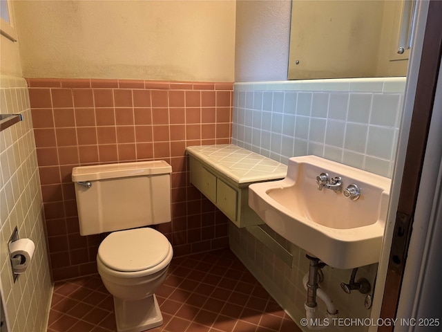 2306 Hill Dr, Bartlesville, OK 74006 - bathroom featuring tile walls, a textured wall, and tile patterned flooring