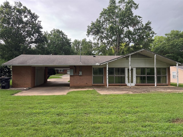 2306 Hill Dr, Bartlesville, OK 74006 - back of property featuring a carport, brick siding, and a yard