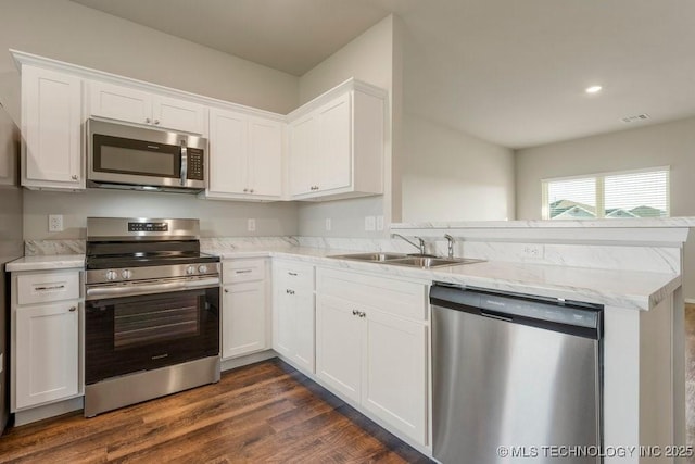 14203 N 76th Ave, Collinsville, OK 74021 - kitchen with stainless steel appliances, a peninsula, white cabinets, dark wood-style flooring, and recessed lighting