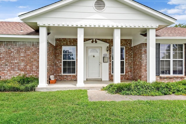 1533 Terrill Cir, Sapulpa, OK 74066 - doorway to property featuring brick siding, roof with shingles, covered porch, and a yard