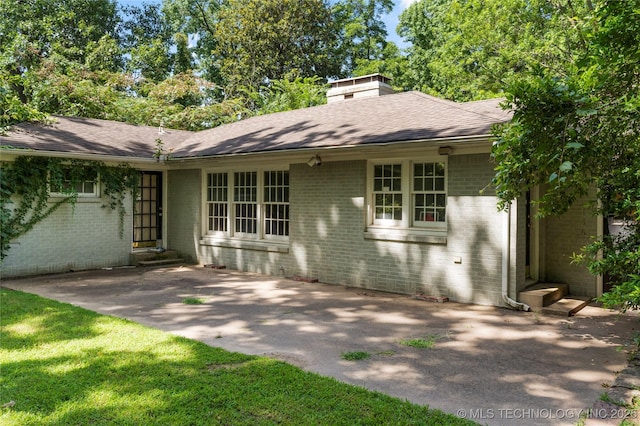 4135 S Zunis Ave, Tulsa, OK 74105 - rear view of property with brick siding, a chimney, roof with shingles, and a patio area