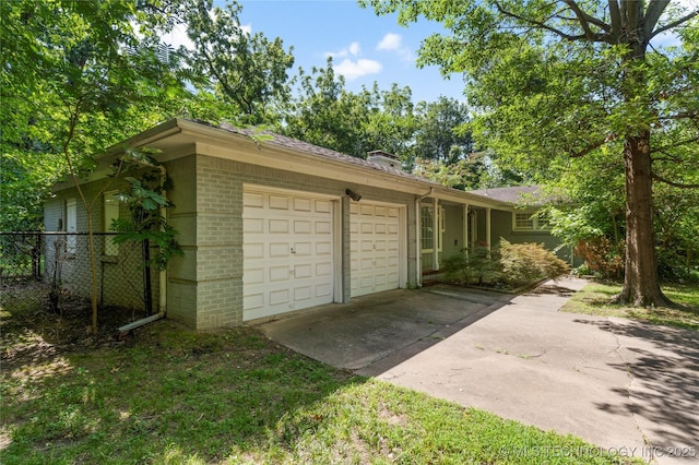 4135 S Zunis Ave, Tulsa, OK 74105 - view of home's exterior featuring brick siding, a garage, a chimney, and driveway