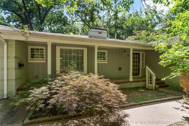 4135 S Zunis Ave, Tulsa, OK 74105 - entrance to property with board and batten siding, a chimney, and covered porch