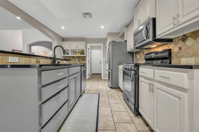 1116 W Fargo Dr, Broken Arrow, OK 74012 - kitchen with appliances with stainless steel finishes, dark countertops, tasteful backsplash, white cabinets, and recessed lighting