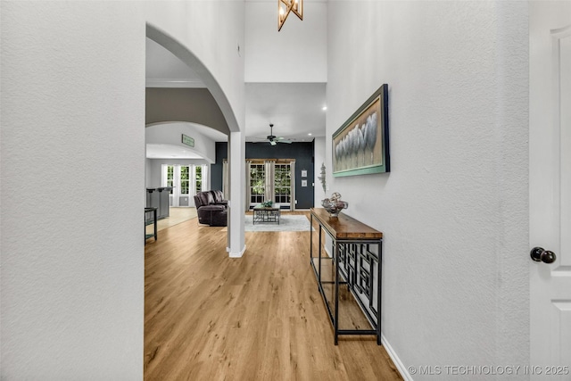 1116 W Fargo Dr, Broken Arrow, OK 74012 - entryway with arched walkways, ceiling fan, wood finished floors, a textured wall, and a towering ceiling