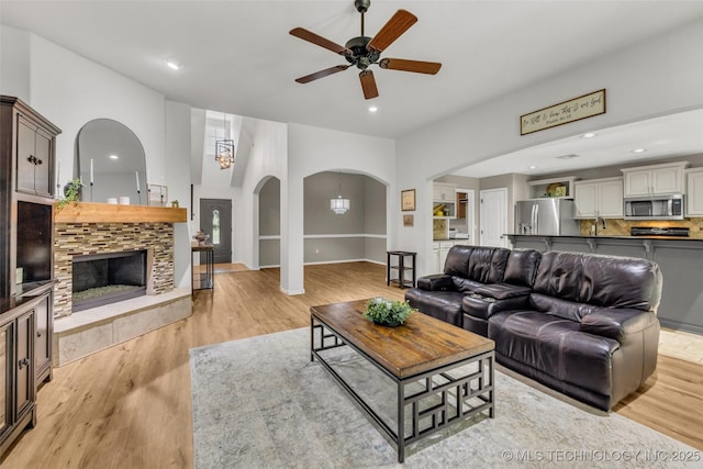 1116 W Fargo Dr, Broken Arrow, OK 74012 - living area featuring ceiling fan, light wood finished floors, arched walkways, recessed lighting, and a tile fireplace