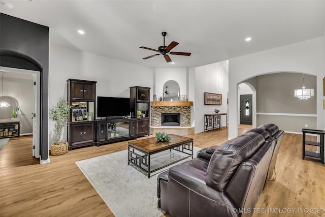 1116 W Fargo Dr, Broken Arrow, OK 74012 - living area with a ceiling fan, arched walkways, light wood finished floors, a tiled fireplace, and recessed lighting