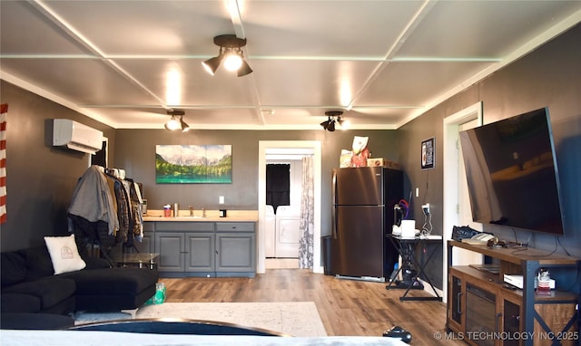 71279 S 270th Rd, Wagoner, OK 74467 - living area featuring a wall mounted AC, washer and clothes dryer, and light wood-type flooring