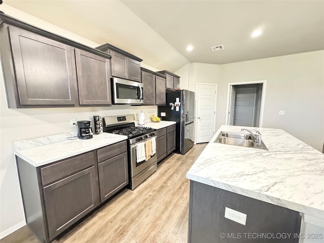 3907 S 150th E Ave, Tulsa, OK 74134 - kitchen featuring appliances with stainless steel finishes, light wood-style floors, light countertops, dark brown cabinetry, and vaulted ceiling