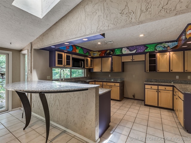 5704 E 65th St, Tulsa, OK 74136 - kitchen with a textured ceiling, a peninsula, light tile patterned flooring, dark stone counters, and glass insert cabinets