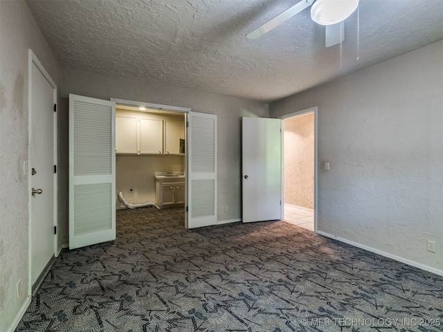 5704 E 65th St, Tulsa, OK 74136 - unfurnished bedroom with dark colored carpet, a textured ceiling, ceiling fan, and ensuite bathroom