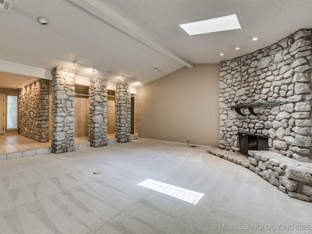 5704 E 65th St, Tulsa, OK 74136 - unfurnished living room with a stone fireplace, carpet flooring, and a skylight